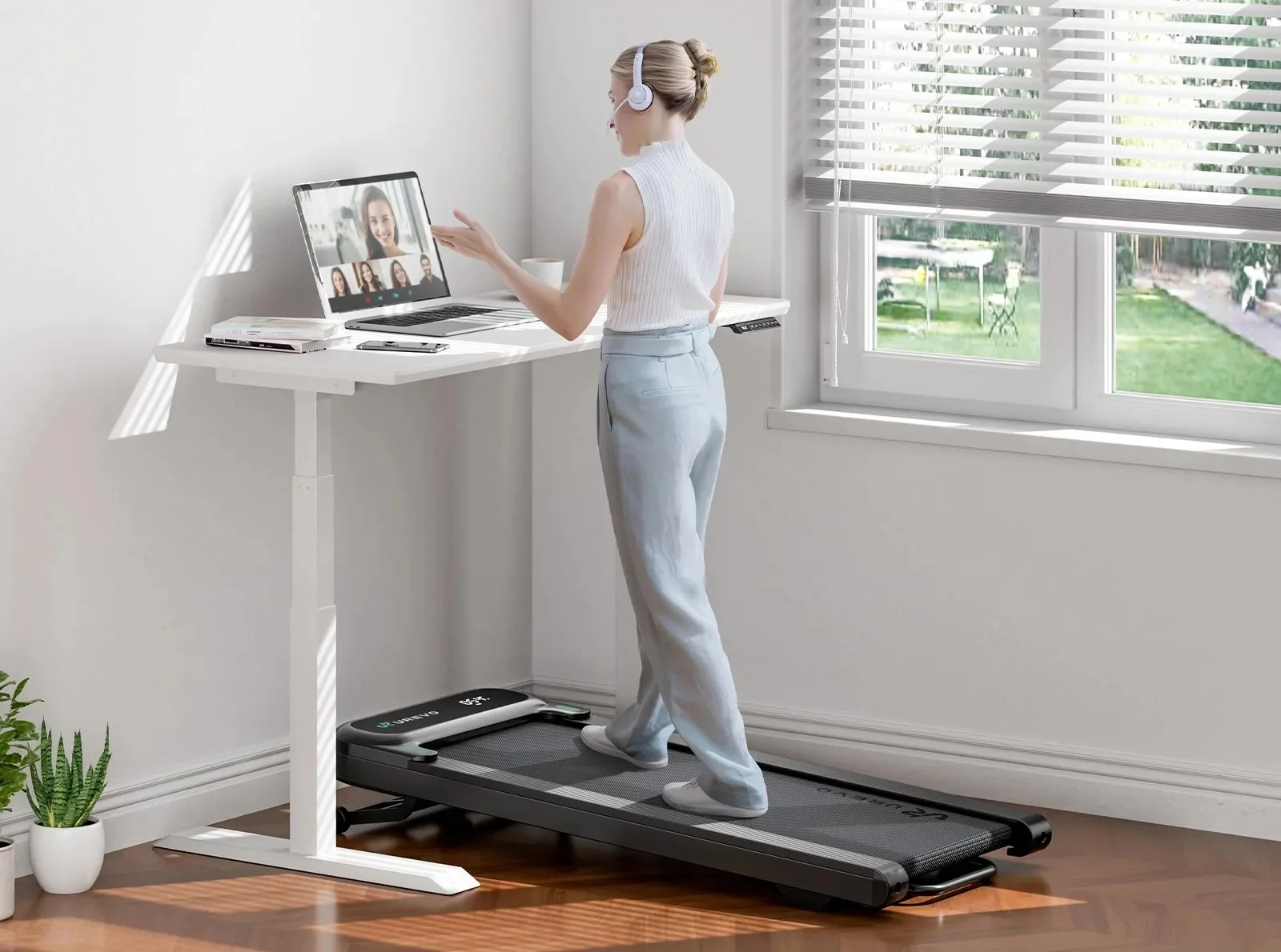 UREVO SpaceWalk 3S treadmill under a standing desk in a sunlit home office
